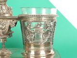 two silver vases sitting on top of a table