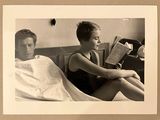 une photo en noir et blanc d'un homme et d'une femme assis sur un lit