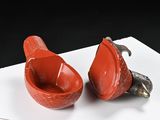 two red bowls sitting on top of a white table