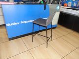 une photo du comptoir d'un atelier de réparation de téléphones portables, avec une chaise placée devant