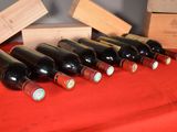 several bottles of wine are lined up on a red table cloth