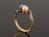 a close up of a gold ring with a pearl and diamonds