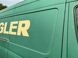 a green van that has a sign on the side of it