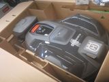 une boîte contenant une tondeuse à gazon noire et grise