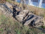 un tas de sacs de sable dans l'herbe, près d'une clôture