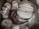 a cardboard box filled with many different types of dishes