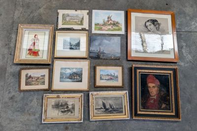many framed pictures on the floor of this room