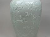 a green vase that has a design on it