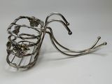 a metal wire basket with a flower design on it