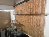 Des bouteilles et des verres sont alignés sur une étagère dans une pièce