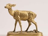 gold deer figurine standing on a base on a white background
