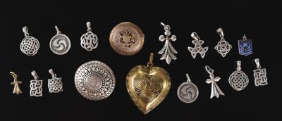 various silver and gold charms on a black background