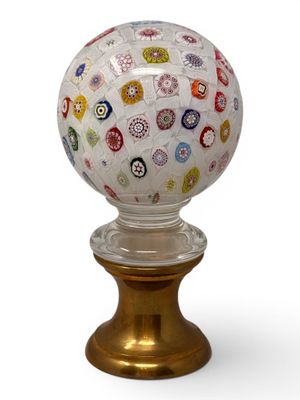 the glass ball is sitting on top of a gold stand