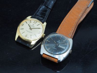 deux montres assises l'une à côté de l'autre sur une surface noire