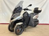 the motorcycle is parked in a garage with a white backdrop