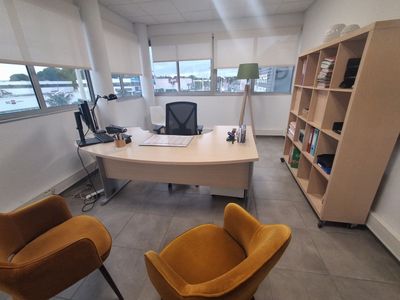 une photo d'un bureau avec un bureau, une chaise et une bibliothèque