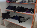 many pairs of shoes on the shelves in the store