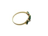 a close up of a gold ring with a green stone