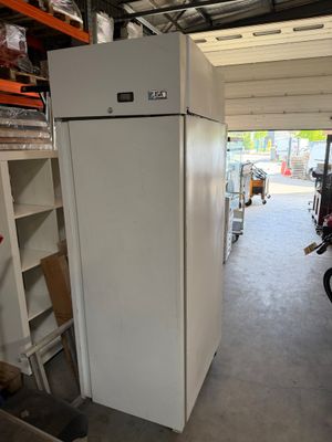a white refrigerator in a garage next to a motorcycle