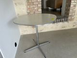 a white table with a silver base in a room