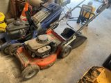 an image of a lawn mower and other tools in a garage