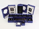 de nombreux bijoux dans une boîte bleue posée sur une surface blanche
