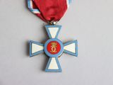 a medal on the neck of a man wearing a red and white ribbon