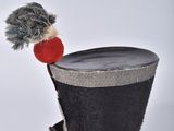 a black top hat with a red pom pom on it