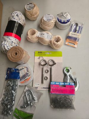 une table sur laquelle se trouvent un tas de pelotes de laine, des ciseaux et d'autres objets