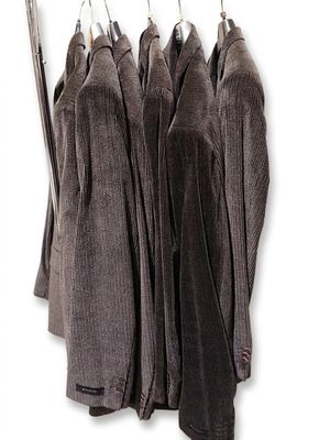 three coats hanging on a clothes rack on a white background