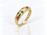 gros plan d'une bague en or avec des pierres multicolores