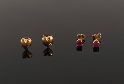 three gold heart shaped stud earrings with a pink stone in the middle