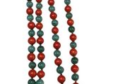 a close up of a long necklace with red and green beads
