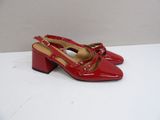 a close up of a pair of red shoes on a white surface
