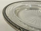 a glass plate with a silver rim on a white table