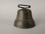 an old bell with a wooden handle on a white surface