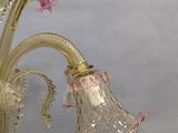 a glass chandelier with pink flowers hanging from it