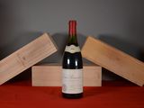 une bouteille de vin posée sur une table, à côté de deux caisses en bois