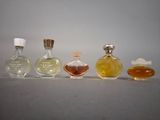 three small bottles of perfume sitting next to each other on a table