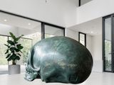 a sculpture of a skull on a pedestal in the middle of a room