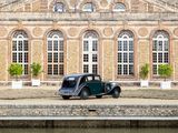 a old car parked in front of a large brick building
