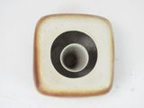 a small square plate with a black and white design on it