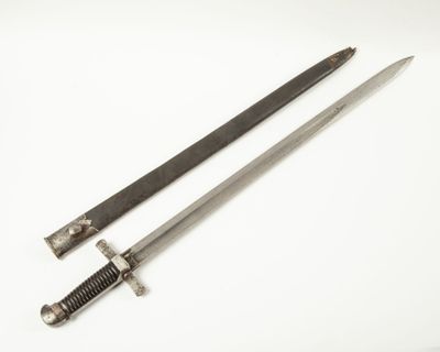 une vieille épée avec un manche en bois sur une surface blanche