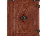 a brown leather book with a decorative design on the cover