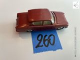 une petite voiture rouge posée sur une feuille de papier bleue