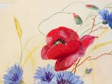 a painting of a red poppy and blue cornflowers on a piece of paper