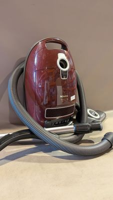 un aspirateur rouge posé sur un plan de travail