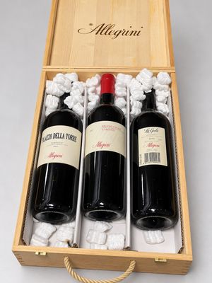 two bottles of red wine in a wooden box on a white surface