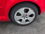 une voiture rouge garée sur le bord de la route