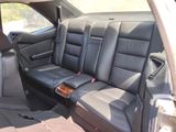 the back seats of a car with a wooden console in the back